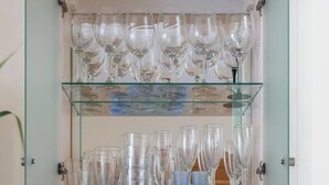 Une vitrine en verre dotée de plusieurs étagères où sont exposés divers objets en verre.