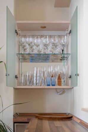 A glass cabinet with multiple shelves holding various glassware. - Spacious and sunny apartment (Riga)