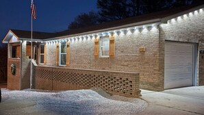 A brick building with a garage, a flagpole with an American flag, and a well-lit exterior.