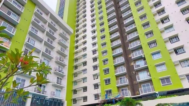 A high-rise residential building with balconies, a swimming pool, and outdoor seating.