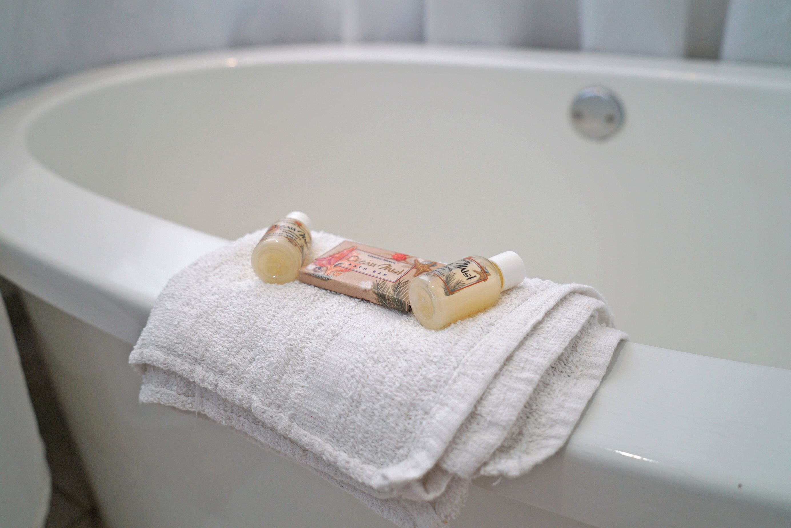 Eine Badewanne mit einem weißen Handtuch und zwei Flaschen Badedarstellung.