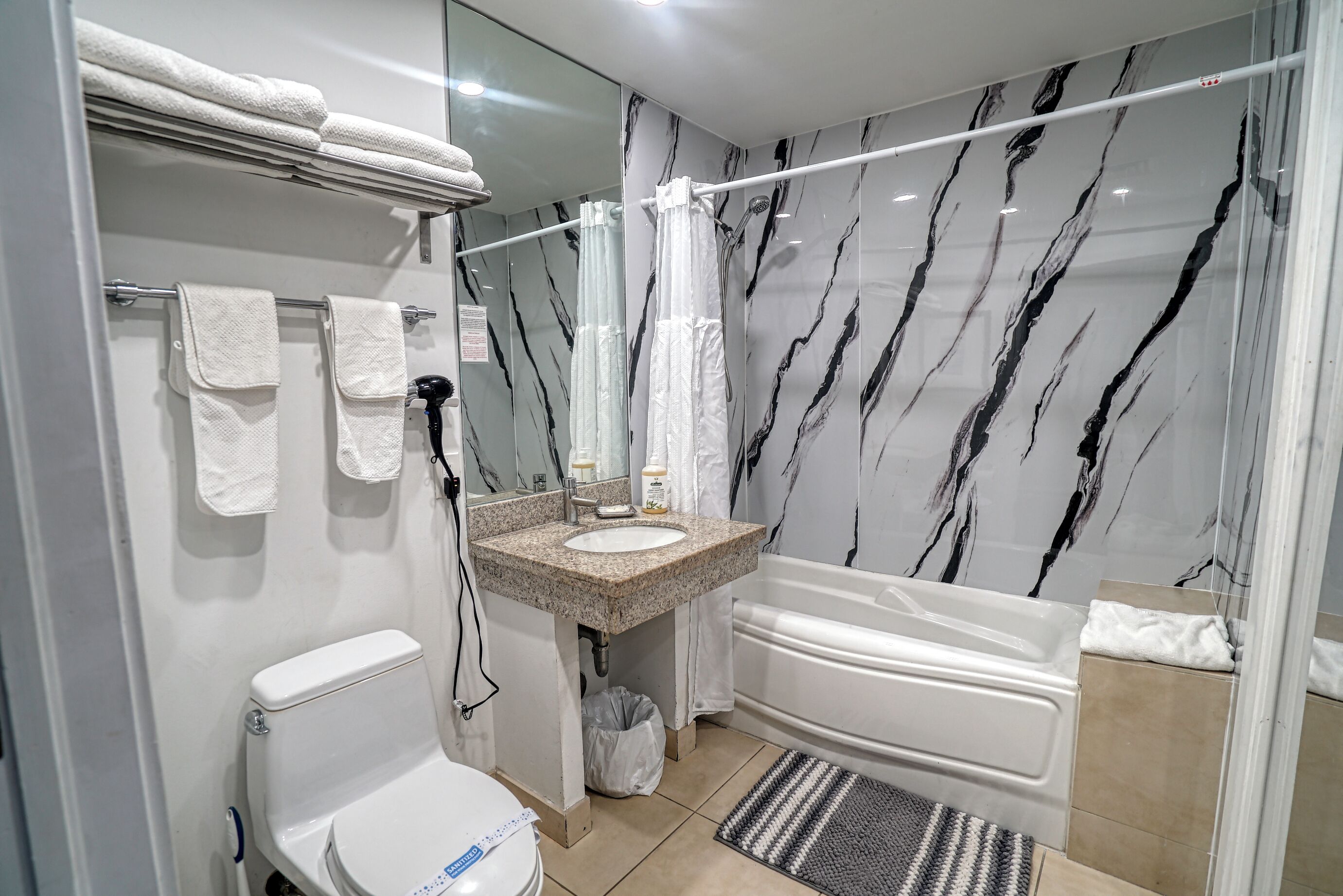 A bathroom with a toilet, sink, and bathtub.