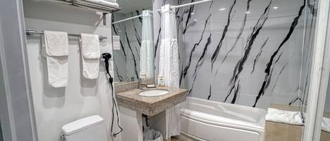 A bathroom with a toilet, sink, and bathtub.