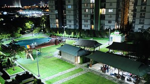 Un complejo residencial con piscina, zonas de estar al aire libre y un césped bien cuidado.