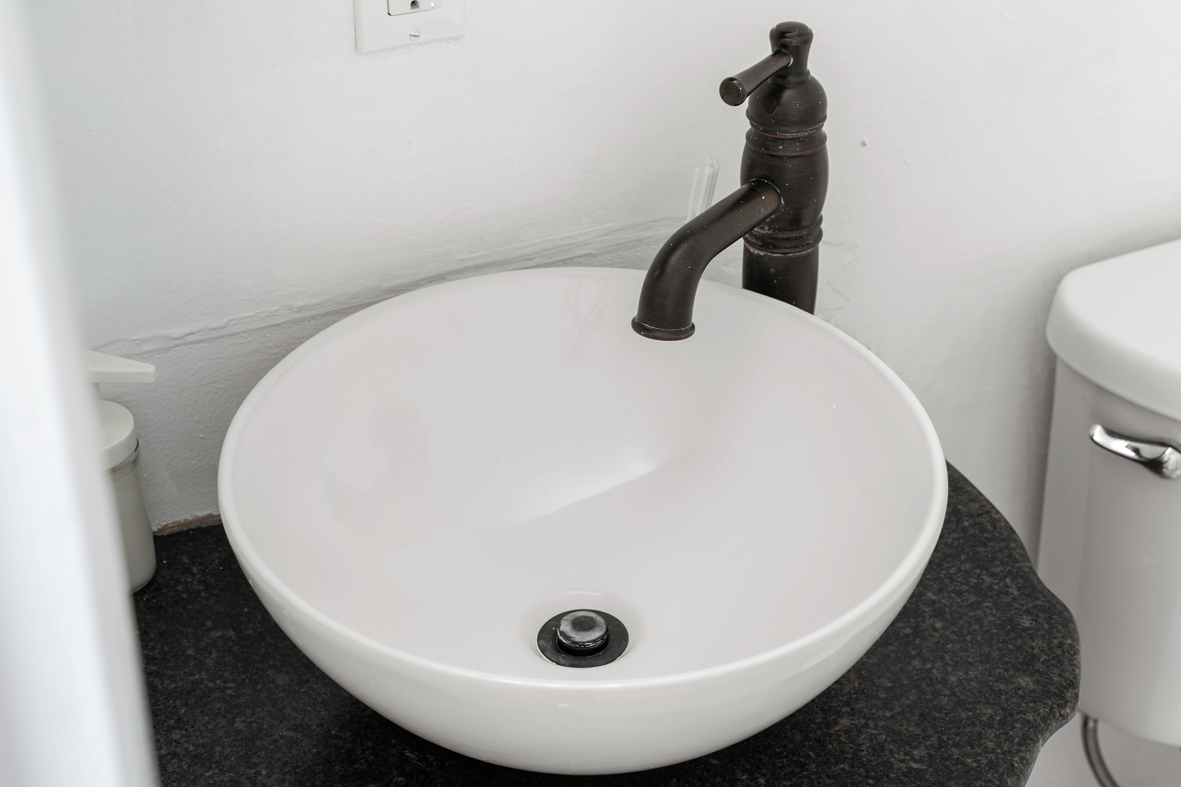 Un lavabo blanc avec un seul robinet dans une salle de bain.