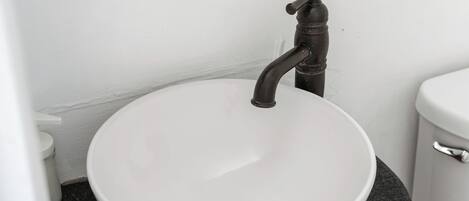 Un lavabo blanc avec un seul robinet dans une salle de bain.