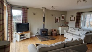 A living room with a television, sofa, and a fireplace.