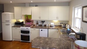 A compact kitchen with white cabinets, a built-in oven, a microwave, and a dishwasher.