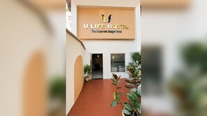 L'ingresso di un hotel con un cartello che riporta la scritta 'U LIFE HOTEL The Corporate Budget Hotel'.