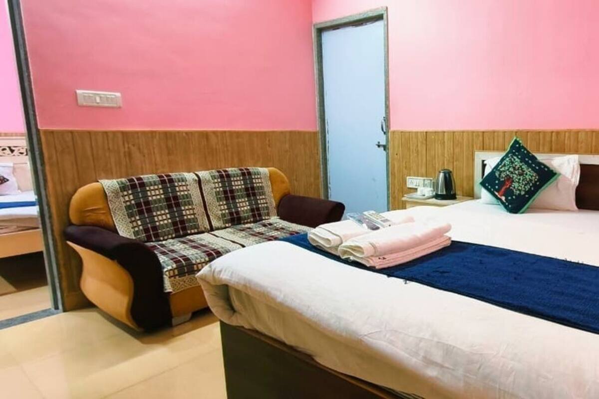 Ein Hotelzimmer mit einem Bett, einem Sessel, einer blauen Decke und einer Tür.