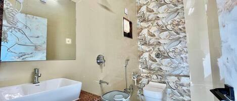 Un baño con un lavamanos grande de color blanco, un espejo, una ducha y un inodoro.
