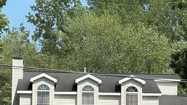 A two-story house with a porch, a front door, and a small front yard.