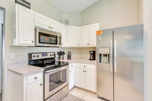 Enjoy cooking in this well-equipped kitchen with a refrigerator, microwave, oven, coffee maker, and knife block.
