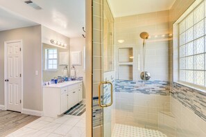 A modern bathroom with a glass-enclosed shower, a vanity with a mirror, and a tiled backsplash. - 6 Mi to Navarre Beach: Dog-Friendly Home w/ Yard (Navarre)