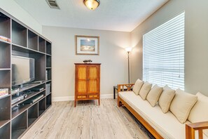 Relax in this stylish living room with an entertainment unit, sofa, and floor lamp.