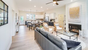 Un salón espacioso con chimenea, comedor y cocina.