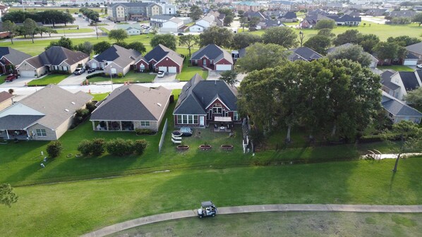 A residential area with houses, lawns, and a golf cart.