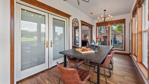 A dining area with a large table, chairs, and a view of the outdoors.