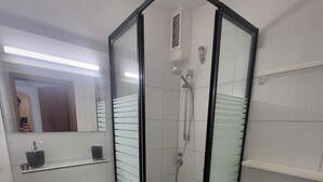 Une salle de bain moderne avec une douche à parois de verre, un lavabo et des toilettes.