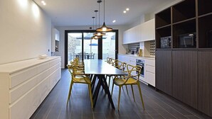 Una cocina moderna con una mesa de comedor, sillas y electrodomésticos integrados.