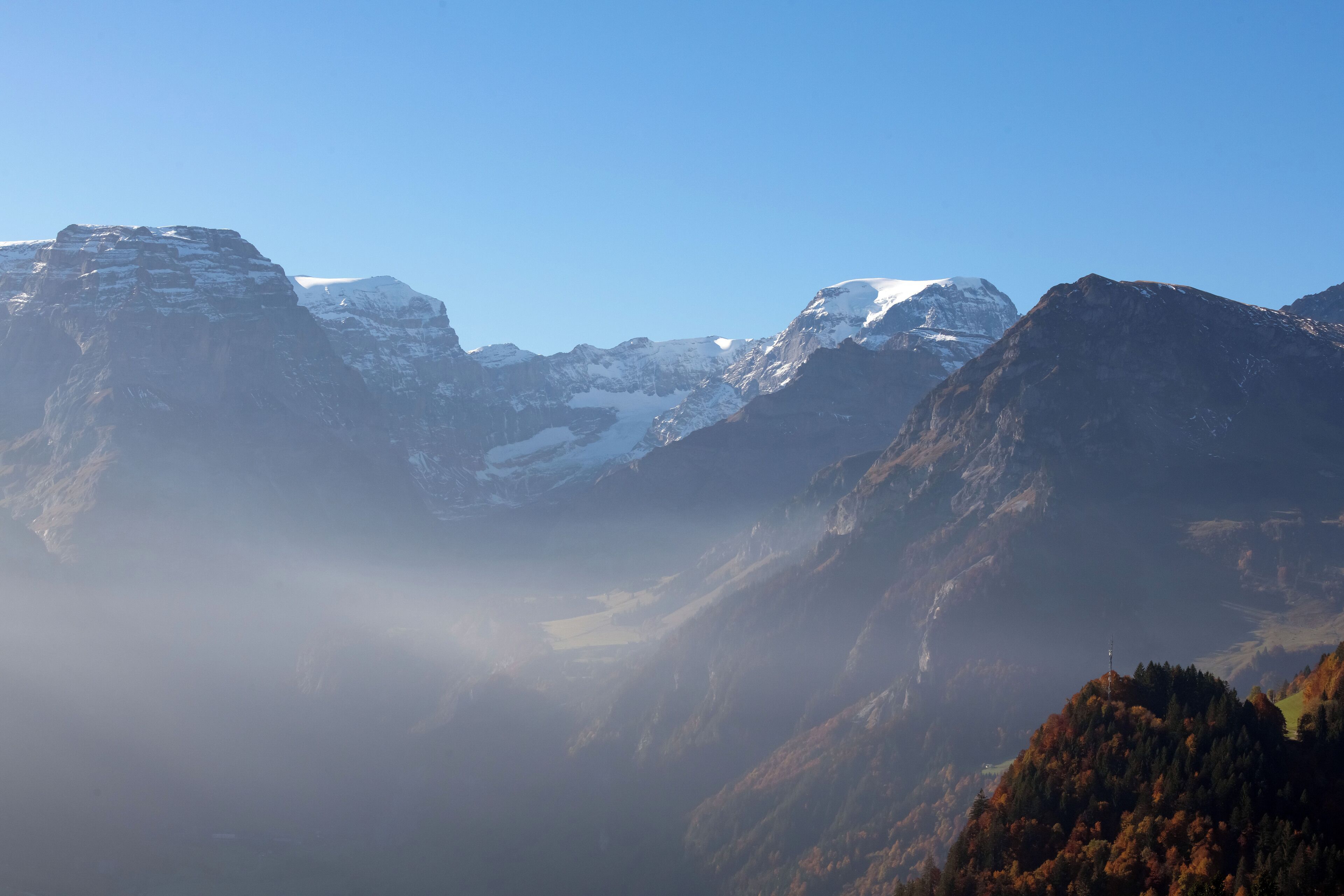 Eine Berglandschaft mit schneebedeckten Gipfeln und einem Tal.
