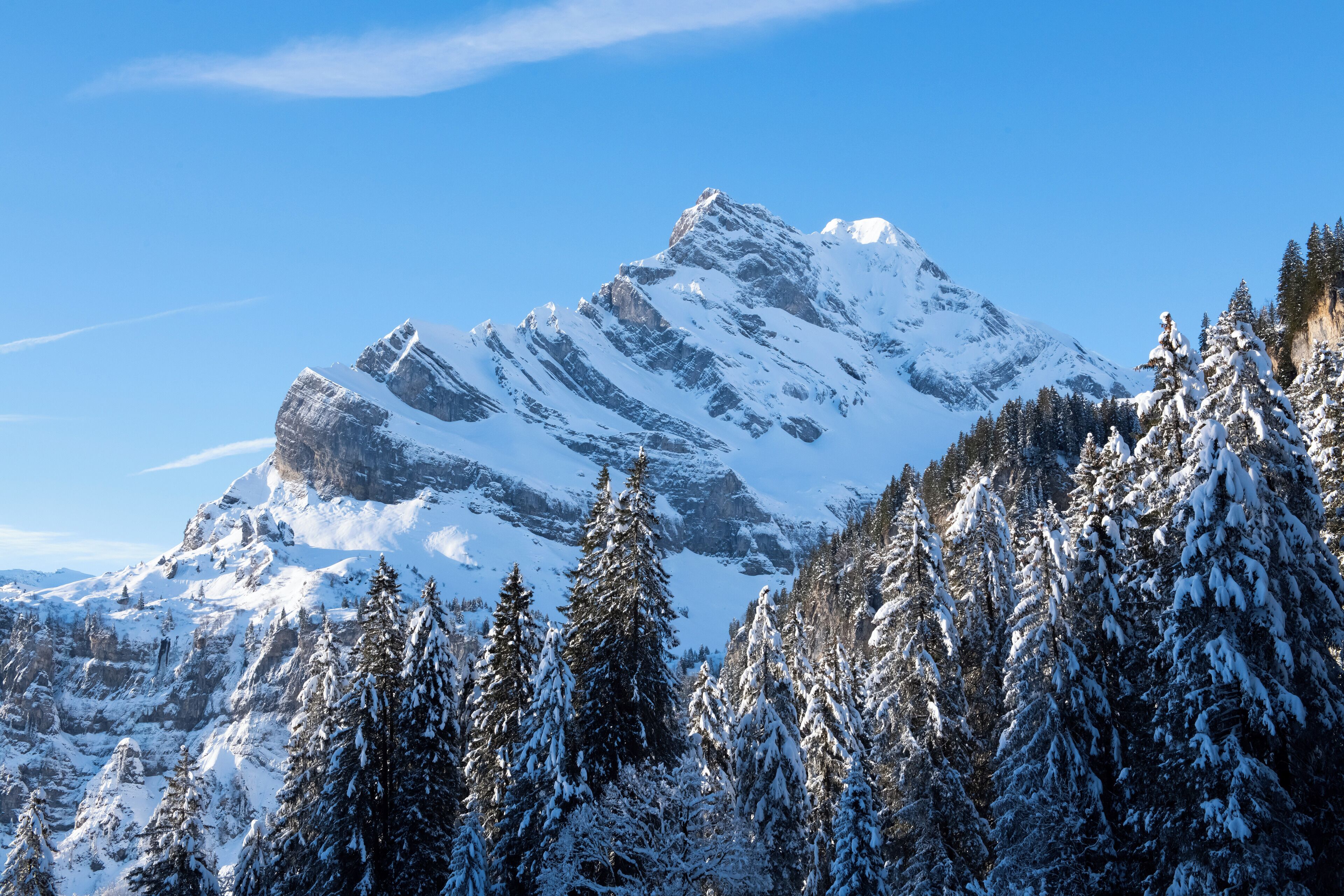 Ein mit Schnee bedeckter Berg unter blauem Himmel.