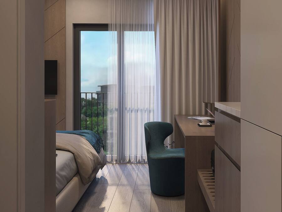 Une chambre d’hôtel moderne, équipée d’un lit, d’un bureau et d’une chaise. Une grande fenêtre, agrémentée de rideaux, donne sur l’extérieur, et la chambre est dotée d’un plancher en bois.