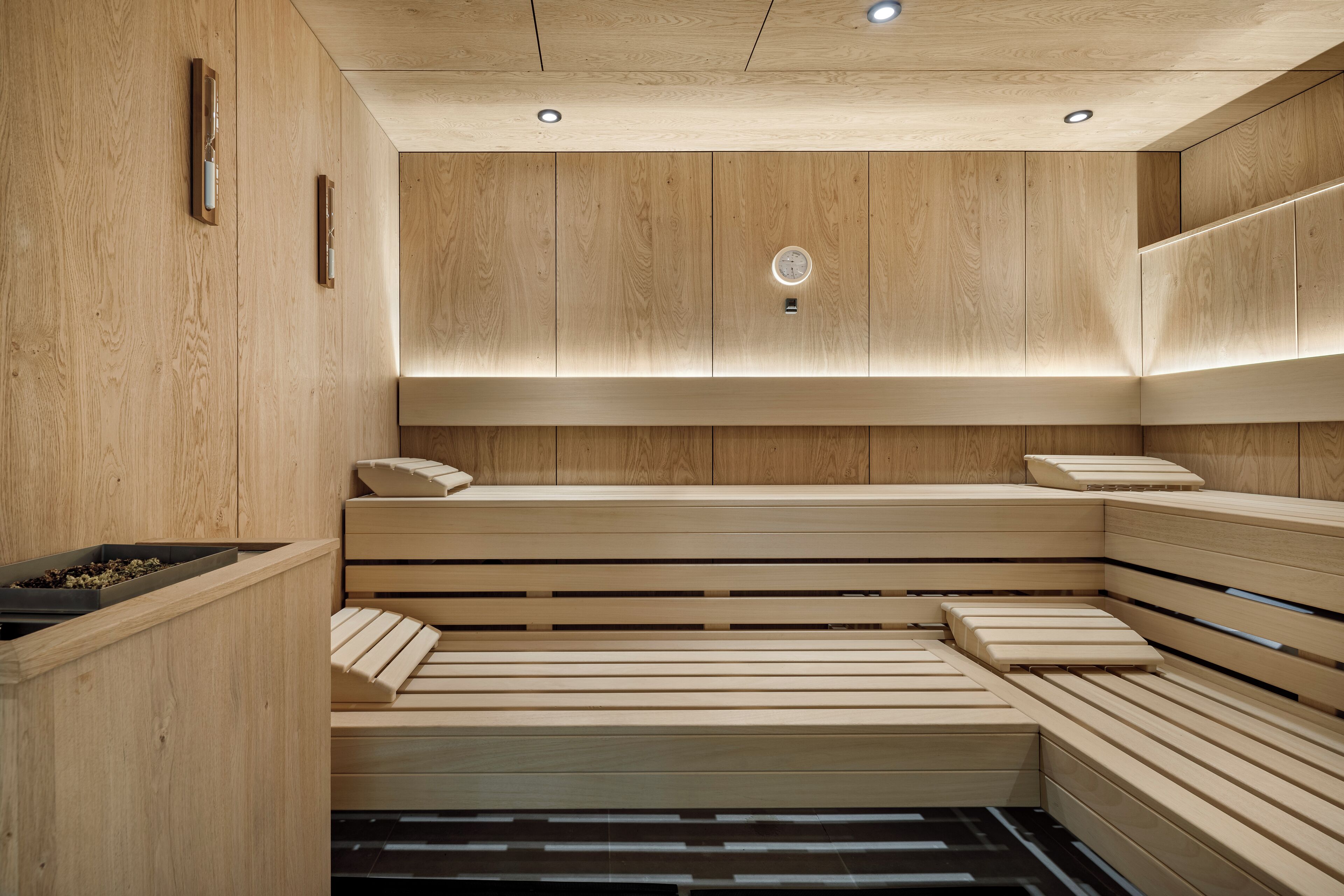 Un sauna avec des bancs en bois et un radiateur fixé au mur.