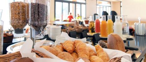 A breakfast buffet with various pastries and beverages.