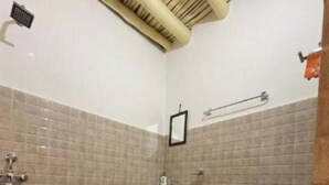 A small bathroom with a toilet, sink, and shower area. - Pangong House Boutique Stay (Leh)
