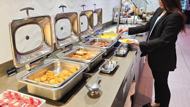 A buffet setup with various food items and a person serving. - Grand Pinnacle Lucknow (Lucknow)