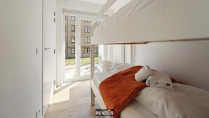 A modern bedroom with a bunk bed, a large window, and a view of a building outside. - James Ensor Zon - beach fun in Oostduinkerke (Oostduinkerke)