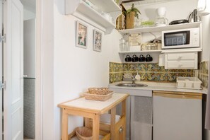 Une cuisine compacte équipée d’un four à micro-ondes, d’un évier et d’une petite table.