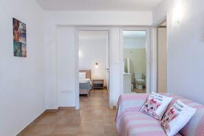 Una camera da letto con un letto, un comodino e un lampadario a parete.