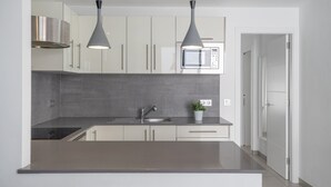 A modern kitchen with a built-in microwave, stainless steel sink, and pendant lighting. - Vacation 'Princesa Teguise' with Shared Pool, Shared Terrace and Wi-Fi (Tías)