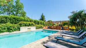 A swimming pool with lounge chairs and a wooden pergola. - Villa 'Charming with Pool' with Private Pool, Wi-Fi and Air Conditioning (Fontvieille)
