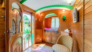 A wooden cabin interior with a bed, a chair, and a small table. - Villa 'Charming with Pool' with Private Pool, Wi-Fi and Air Conditioning (Fontvieille)