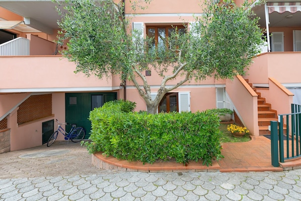 Un edificio con una escalera, un árbol y una bicicleta.