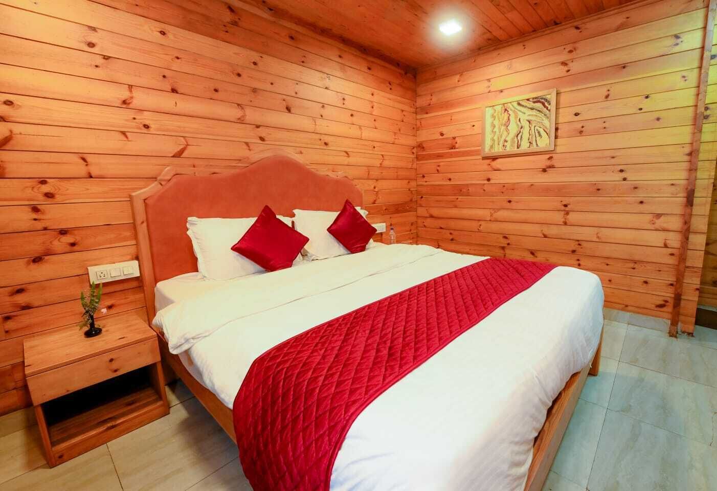 A wooden-paneled room with a bed, a nightstand, and a wall-mounted artwork.