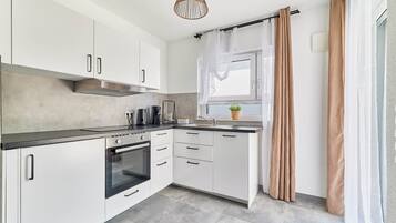 Frigorífico grande, horno, placa de cocina y utensilios de cocina