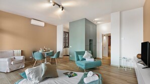 A modern hotel room with a bed, a sofa, a dining area, and a TV. - Mon Reve Lake View Pool, Stresa (Stresa)