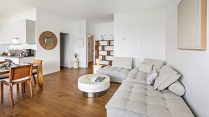 A modern living room with a wooden dining table, a round coffee table, and a large beige sofa. - Mon Reve Lake View Pool, Stresa (Stresa)