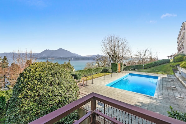 Une piscine offrant une vue sur les montagnes et un plan d’eau.