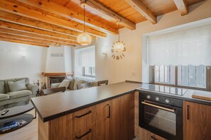 A modern kitchen with wooden cabinets, a central island, and a built-in oven. - Holiday Home 'La Cabaña De Cascajares' with Mountain View, Balcony and Wi-Fi (Cascajares de la Sierra)