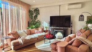 A living room with a sofa set, a TV, and a fireplace. - Soft Modern Glamour in the Heart of Camberwell (Camberwell)