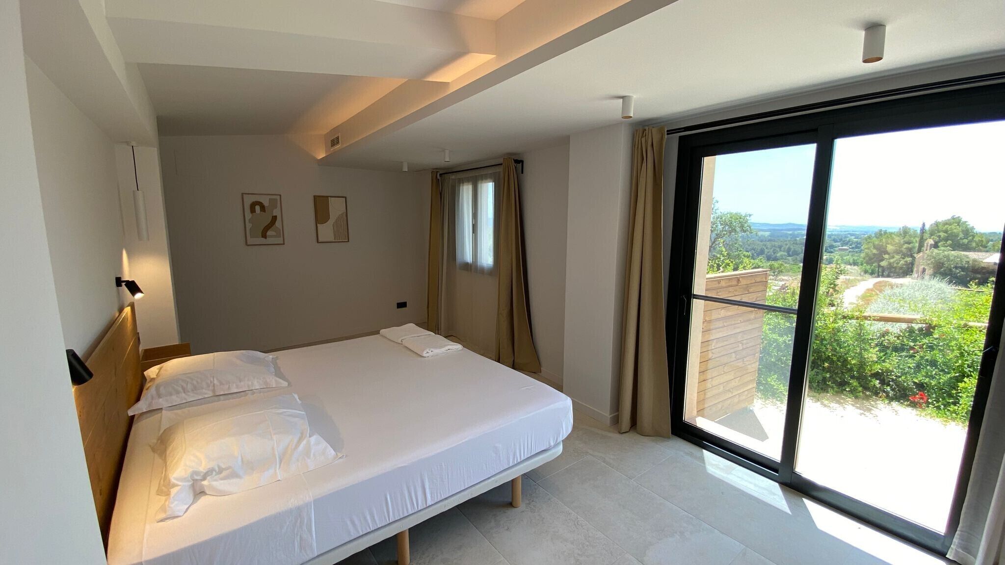 A bedroom with a bed, a window with a view, and a ceiling light.