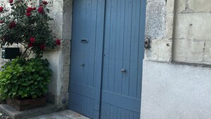 A blue double door with a number plate '290' above it, set in a stone building with a metal pipe to the left. - Spa suite, bohemian ambience & romantic experience (Saumur)