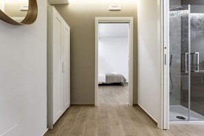 Ein Flur mit einem Bett, einer Dusche und einem Kleiderschrank.
