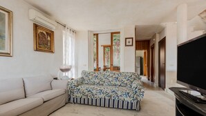 A living room with a sofa, a TV, and a patterned rug.