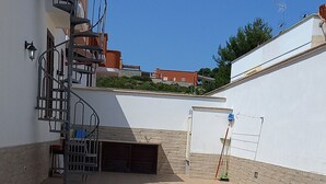 A courtyard with a spiral staircase, a covered area, and a wall with a ladder. - Holiday Home 'Villetta Lucy' with Sea View, Private Terrace and Air Conditioning (Salve)